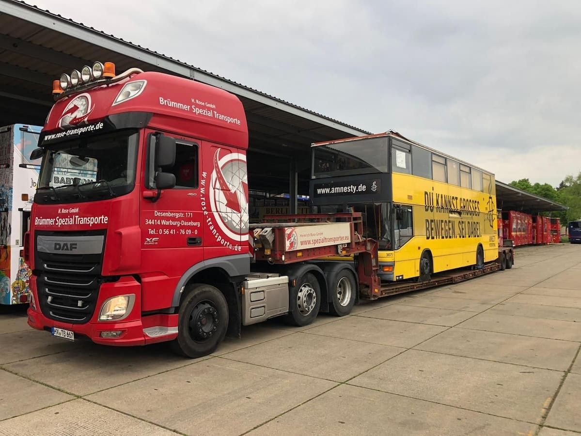 Transporter beladen mit Reisebus